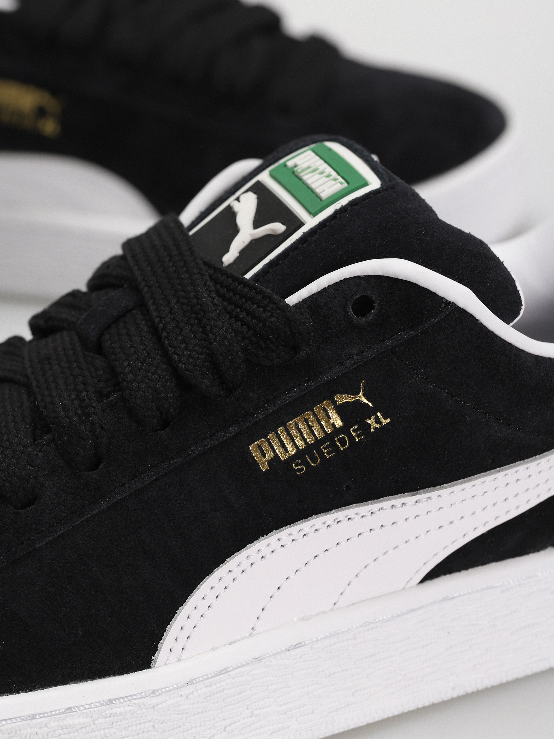 Black fashion and white suede pumas